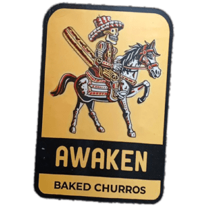 Awaken Baked Churros wanted sticker spotted in Edinburgh in 2025